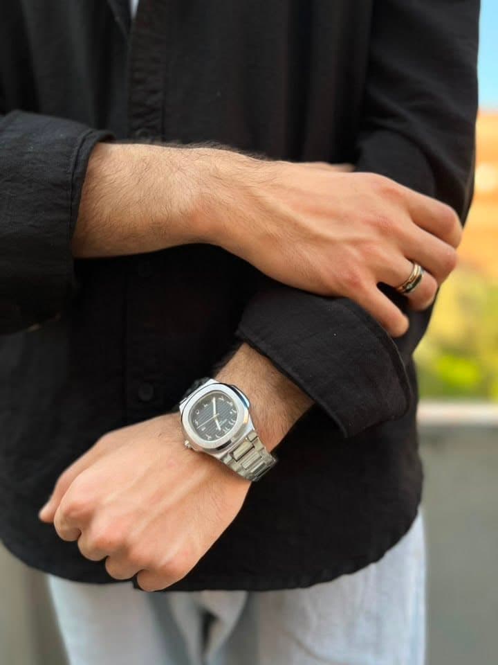 White dial metal watch styled with a black shirt